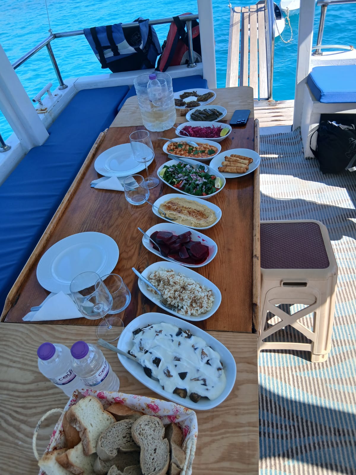 Meze lunch laid out on the deck table: hummus, dolma, salad and bread